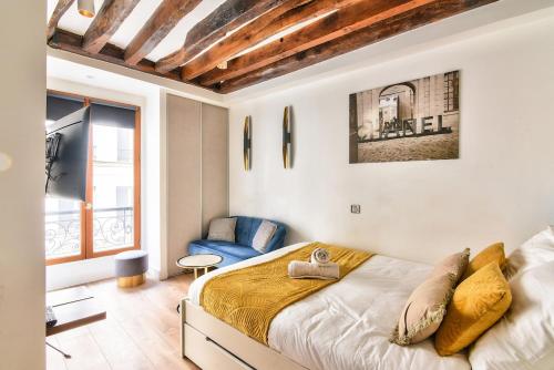 une chambre avec un lit, une chaise et une fenêtre dans l'établissement Studio Paris Centre near Montorgueil, à Paris