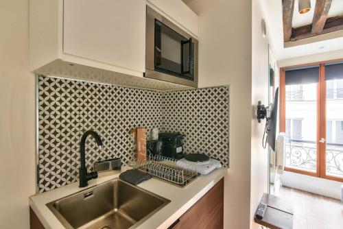 une cuisine avec un évier et un plan de travail dans l'établissement Studio Paris Centre near Montorgueil, à Paris