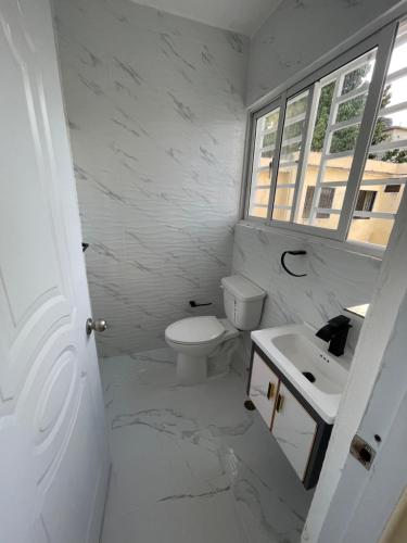 a white bathroom with a sink and a toilet at Apartamento in Cancino