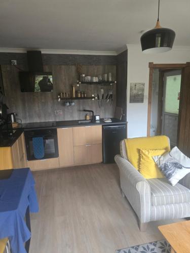 a living room with a couch and a kitchen at Aaron's Bothy in Portree