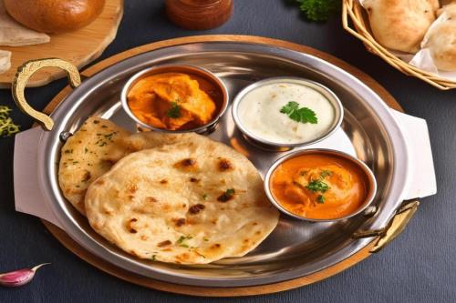 a plate of food with hummus and some dipping sauces at Perfectstayz Premium Westend at Mall Road in Mussoorie