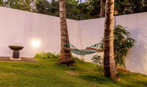 a hammock between two palm trees in a yard at Pleasure Villa in Matara