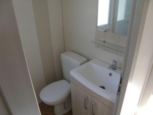 une petite salle de bain avec toilettes et lavabo dans l'établissement Bungalow convivial près de Saint-Jean-de-Monts avec jardin_2, à Saint-Jean-de-Monts