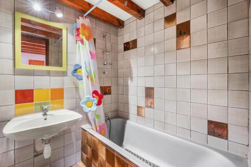 une salle de bain avec un lavabo et une baignoire dans l'établissement Bastidon Avec Terrasse Vue Mer, à Carqueiranne