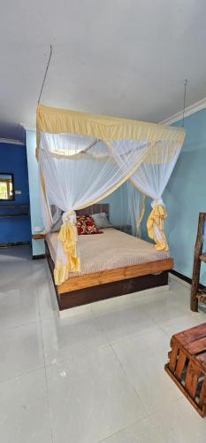 a bedroom with a bed with a canopy at Z Village Lodge in Paje