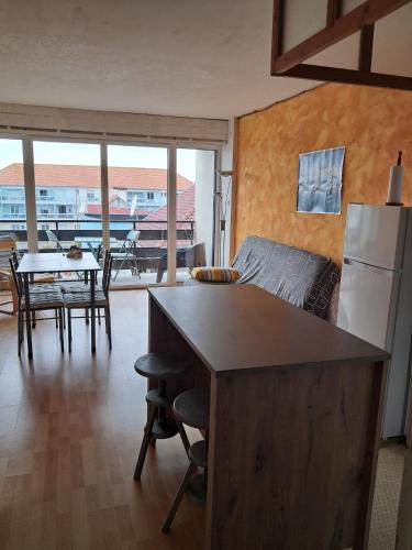 Il dispose d'une cuisine et d'un salon avec un réfrigérateur et une table. dans l'établissement Tamaris 42, à Quend-Plage