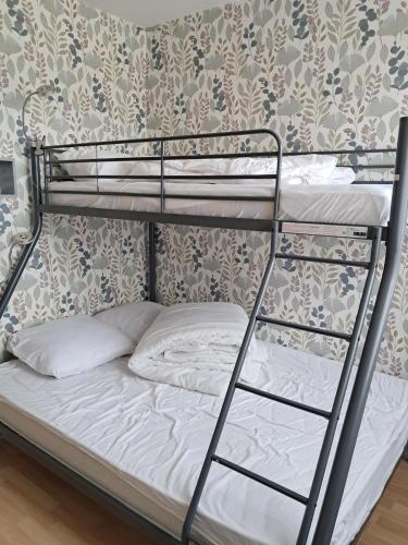 a bunk bed with white sheets and a white pillow at Tamaris 42 in Quend-Plage