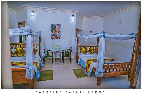 a bedroom with two bunk beds and a table at Parkside Safari Lodge in Pakwach East