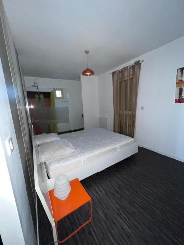 Cette petite chambre comprend un lit et une table orange. dans l'établissement La maison fitness, à Castang