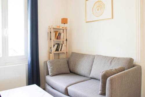 un salon avec un canapé et une étagère dans l'établissement Charming T2 in Ivry-sur-Seine near Paris, à Ivry-sur-Seine