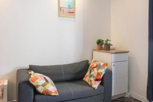 - un salon avec un canapé bleu et 2 oreillers dans l'établissement Charming T2 in Ivry-sur-Seine near Paris, à Ivry-sur-Seine