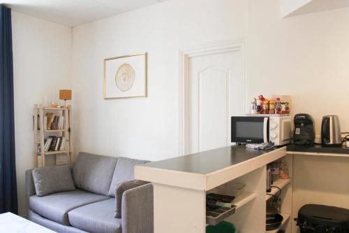 un salon avec un canapé et un bureau dans l'établissement Charming T2 in Ivry-sur-Seine near Paris, à Ivry-sur-Seine