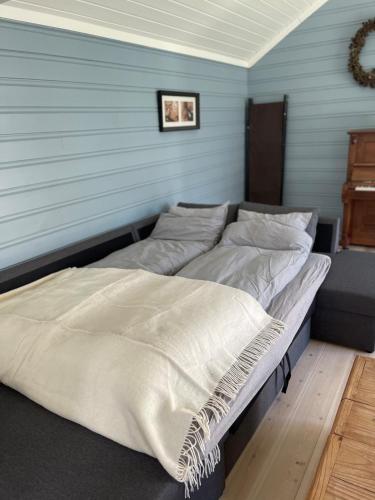 two beds in a room with a blue wall at Recently Refurbished Farm House in Larvik