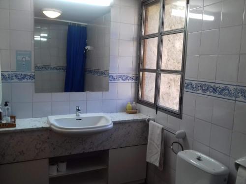 łazienka z umywalką, toaletą i lustrem w obiekcie Casa Julián Fábrica Giner w mieście Morella