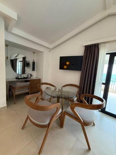 a living room with a glass table and chairs at Coral Strand Smart Choice in Beau Vallon