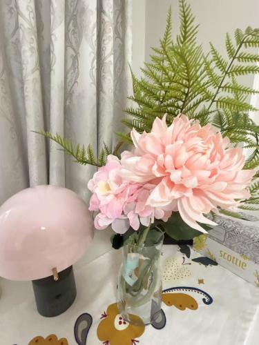 a vase filled with pink flowers on a table at ReimiMondo 303 in Tokyo