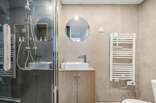 a bathroom with a sink and a shower with a mirror at Le Cocon - Studio Proche Disney & Paris - Wifi in Lagny