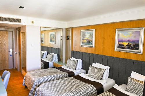 a hotel room with three beds and chairs at Porto Bello Hotel Resort & Spa in Antalya