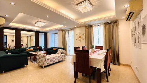 Una sala de estar con una mesa y un comedor. en Olive Service Apartments Safdarjung Enclave, en Nueva Delhi