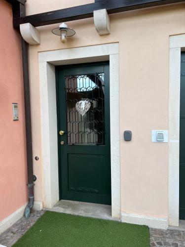 a green door with a fence on a house at Terme Colli Golf - Suite La Montecchia in Montecchia