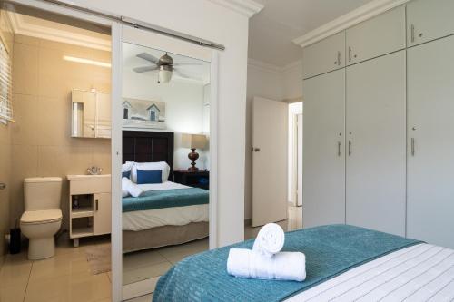 a bedroom with a bed and a bathroom at Happy Escape in Umdloti