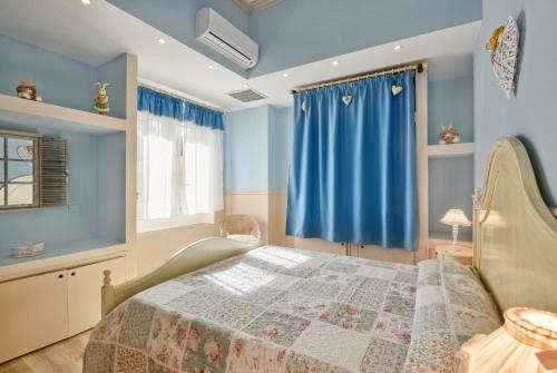 a bedroom with a bed with blue walls and blue curtains at La Bouganville Holiday House in Agropoli