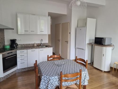 a kitchen with a table and a kitchen with white cabinets at Le Domaine d'Arignac in Arignac