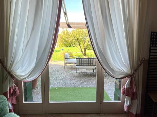 a sliding glass door with a view of a yard at Terme Colli Golf - Suite La Montecchia in Montecchia