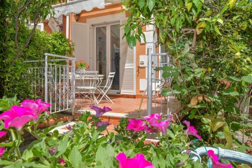 a porch with a table and chairs and flowers at La Bouganville Holiday House in Agropoli