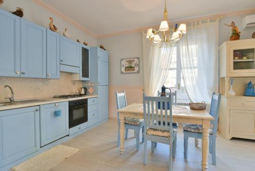 a kitchen with blue cabinets and a table and chairs at La Bouganville Holiday House in Agropoli