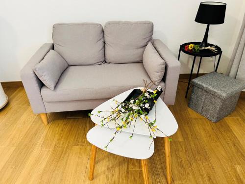 a living room with a couch and a table with flowers on it at Le Domaine d'Arignac in Arignac