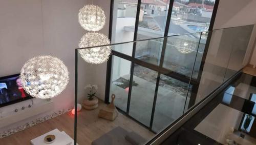 Cette chambre est dotée de murs en verre et de lustres. dans l'établissement Magnifique Villa piscine privée jacuzzi, à Saint-Féliu-dʼAvall