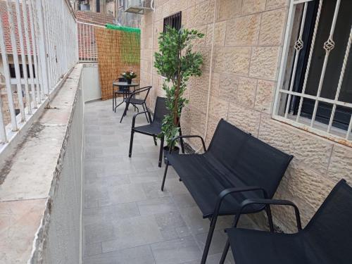 エルサレムにあるPERGOLA penthouse 3 bdr in centerのパティオの黒い椅子