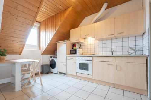 une cuisine avec des appareils blancs et un plafond en bois dans l'établissement Bel appartement 3Pers Stationnement Gratuit Centre, à Mulhouse