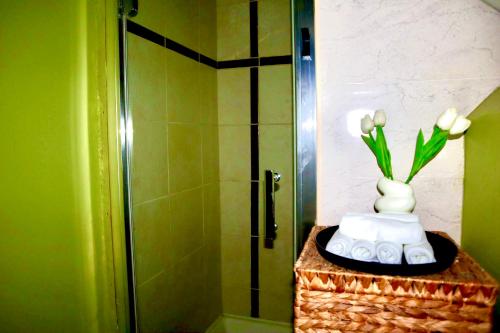 a bathroom with a shower with a vase of flowers at The Church E in Manchester