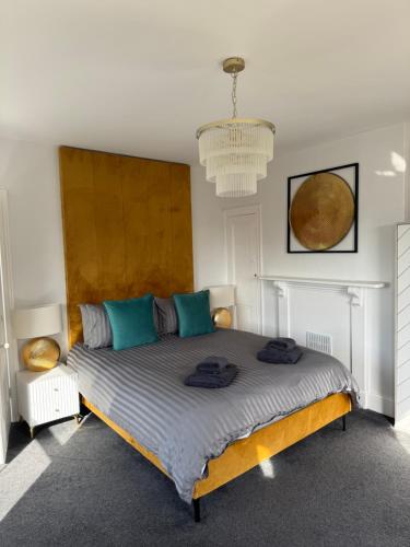 a bedroom with a large bed with blue pillows on it at Stylish One Bedroom Apartment in Norwich