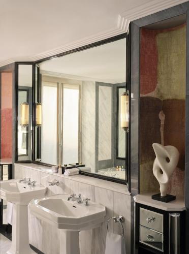 a bathroom with two sinks and a large mirror at Baur au Lac in Zürich