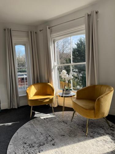a living room with two chairs and a table and a window at Stylish One Bedroom Apartment in Norwich