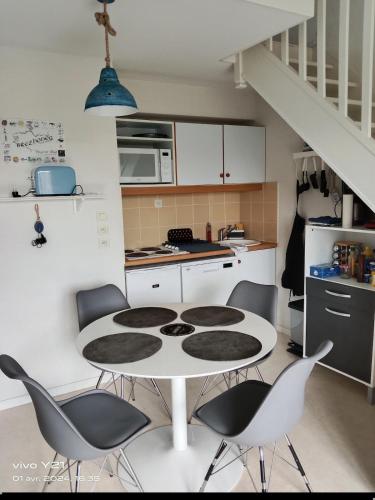 une cuisine avec une table et des chaises dans une pièce dans l'établissement Appartement lumineux, à Arzal