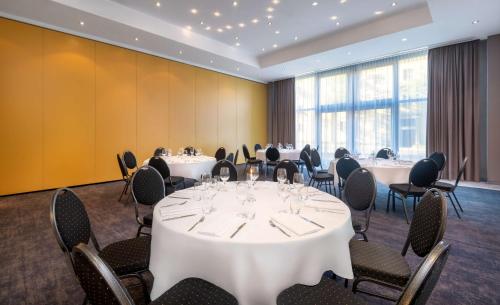 a conference room with white tables and chairs at Radisson Blu Fürst Leopold Hotel in Dessau