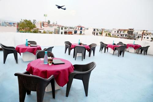 a row of tables with red table cloths on a roof at Hide n Seek in Dehradun Airport