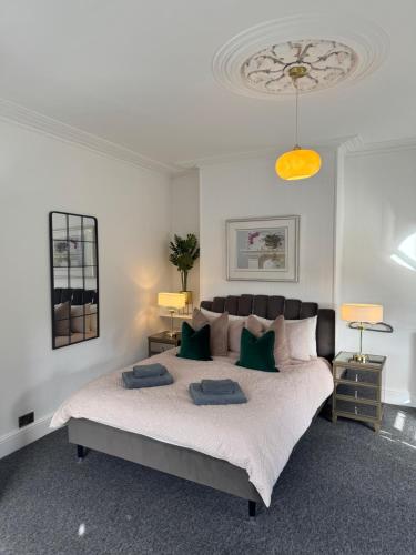 a bedroom with a large bed with green pillows at Luxury One Bedroom Apartment in Norwich