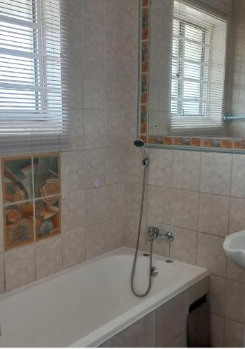 a bathroom with a bath tub and a sink at Afsaal Sea view apartments in Amanzimtoti