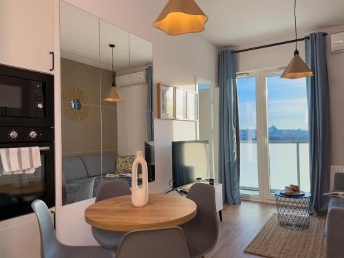 Una sala de estar con mesa y sillas y una cocina. en URBAN APARTMENTS GLOBAL, 12th Floor No 23A, Free Garage, Self Check-in, No Deposit, en Katowice