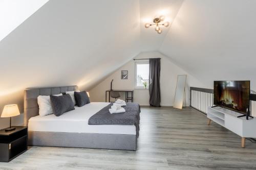 a bedroom with a bed and a flat screen tv at GT-City Suite 02 I Gasgrill I Smart-TV I Balkon in Gütersloh
