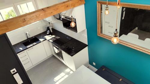 - une vue de tête sur la cuisine équipée d'un évier et d'un miroir dans l'établissement Charming House - Ideal for Families, à Versailles