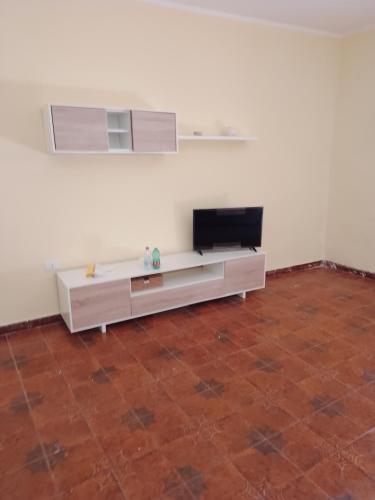 a living room with a television and a couch at Appartamento Stio in Stio