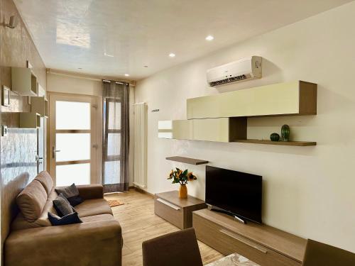 a living room with a couch and a flat screen tv at La Casa di Francy B&B in Castellaneta