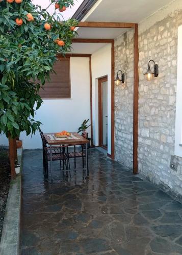 a patio with a table and an orange tree at Iris House - Casa indipendente a Berat in Berat