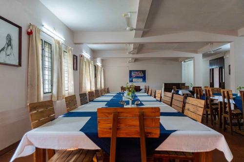 Un comedor largo con una mesa azul y blanca. en Gama Heritage Residency, en Kochi